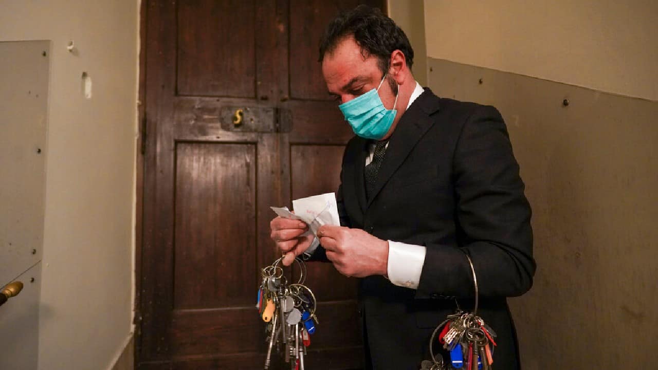 There, at a tiny wooden doorway, Crea drew out a white envelope from his suit pocket, ripped it open and pulled out a small silvery-brass key. (Image: AP)