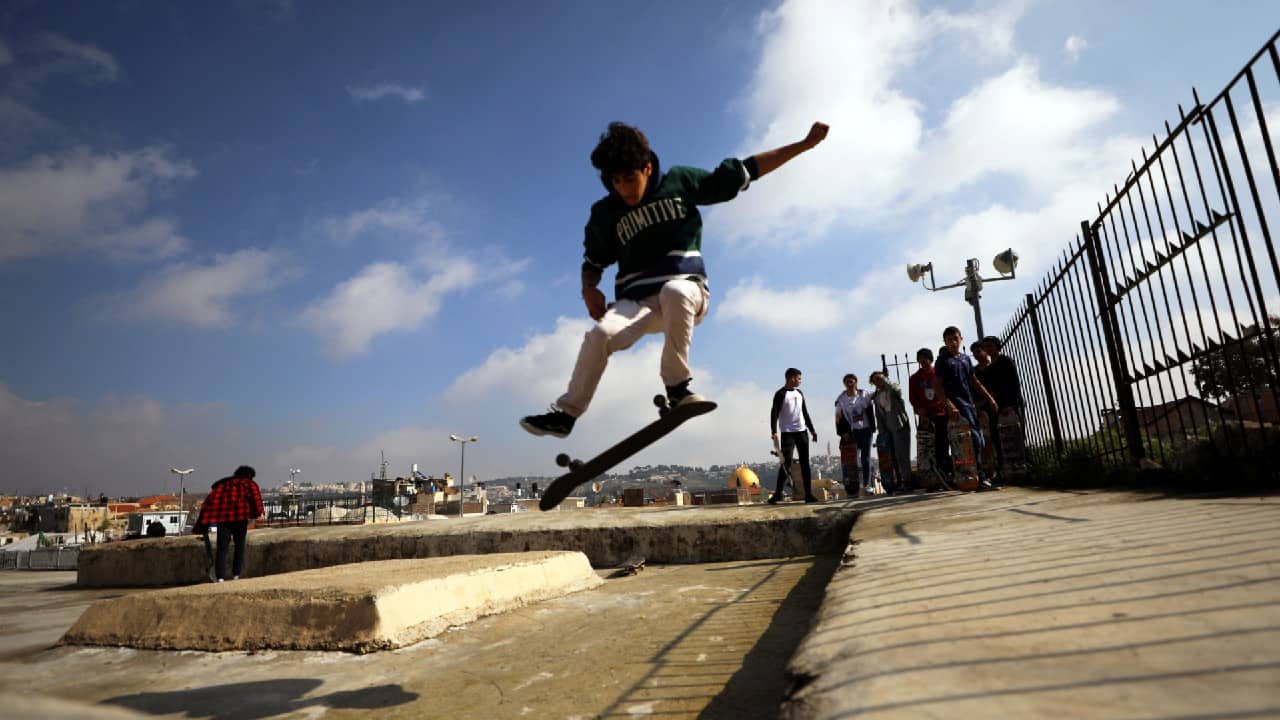 A Palestinian youth jumps with his skateboard on a rooftop as the Dome of the Rock located on the compound known to Muslims as Noble Sanctuary and to Jews as Temple Mount is seen in the background, as Israel partially lifts its third national lockdown to fight the coronavirus disease (COVID-19) crisis, in Jerusalem's Old City February 7. (Image: Reuters)