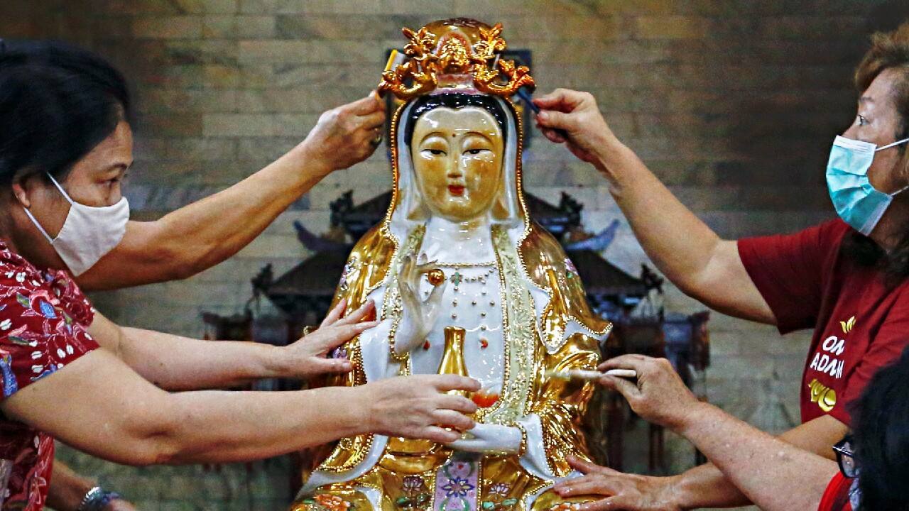 Women wearing protective face masks wash a religious statue ahead of the Chinese Lunar New Year celebration following the coronavirus disease (COVID-19) outbreak, at a temple in Jakarta, Indonesia, February 4. (Image: Reuters)