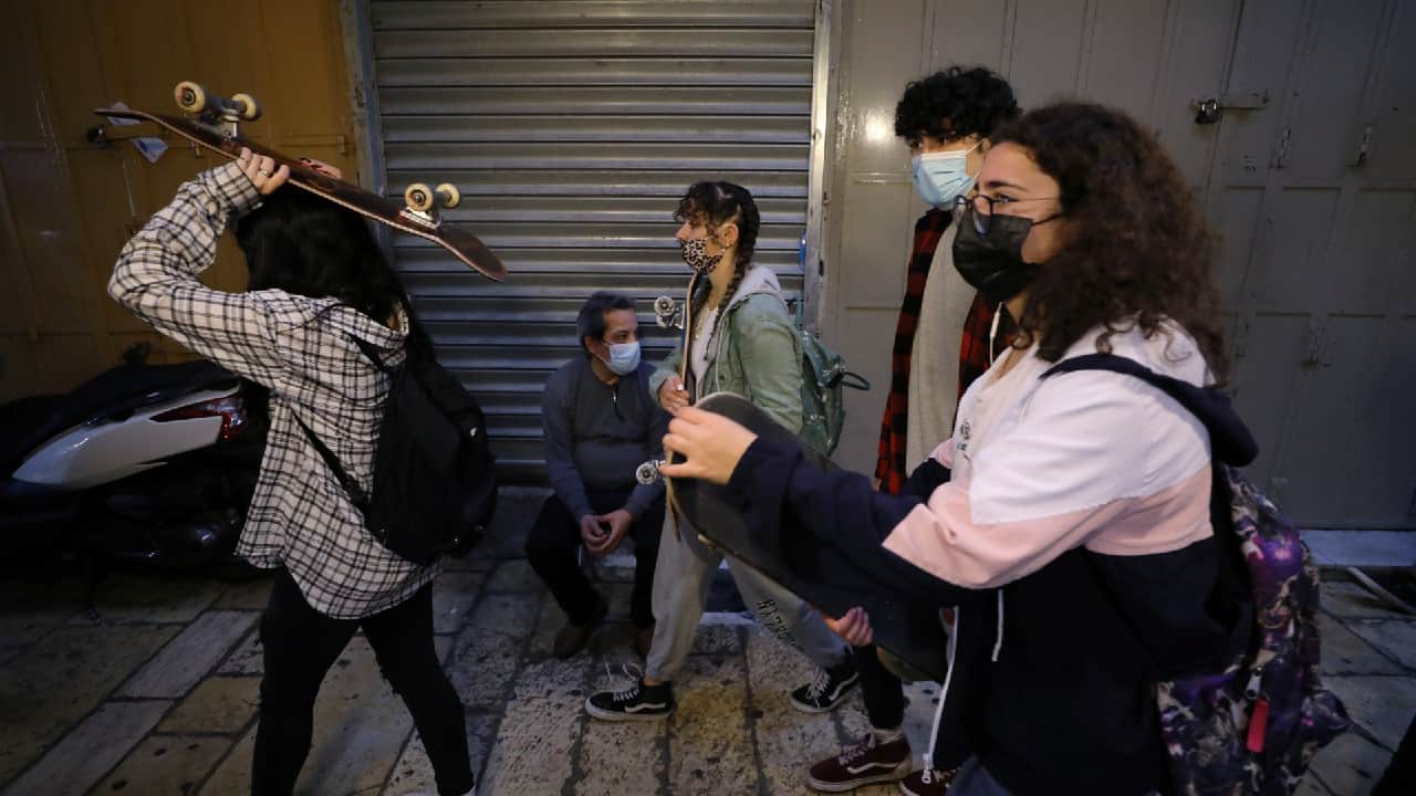 Palestinian youths hold their skateboards while walking past shuttered shops as Israel partially lifts its third national lockdown to fight the coronavirus disease (COVID-19) crisis, in Jerusalem's Old City February 7. (Image: Reuters)