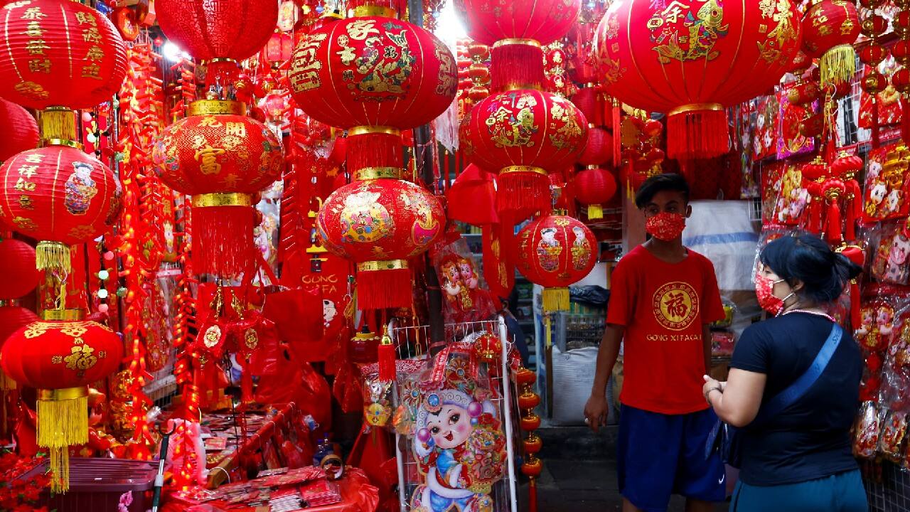 Vendor wearing a protective mask serves a customer inside a stall selling decorations at a street market ahead of the Lunar New Year, following the coronavirus disease (COVID-19) outbreak, in Jakarta, Indonesia, February 4. (Image: Reuters)