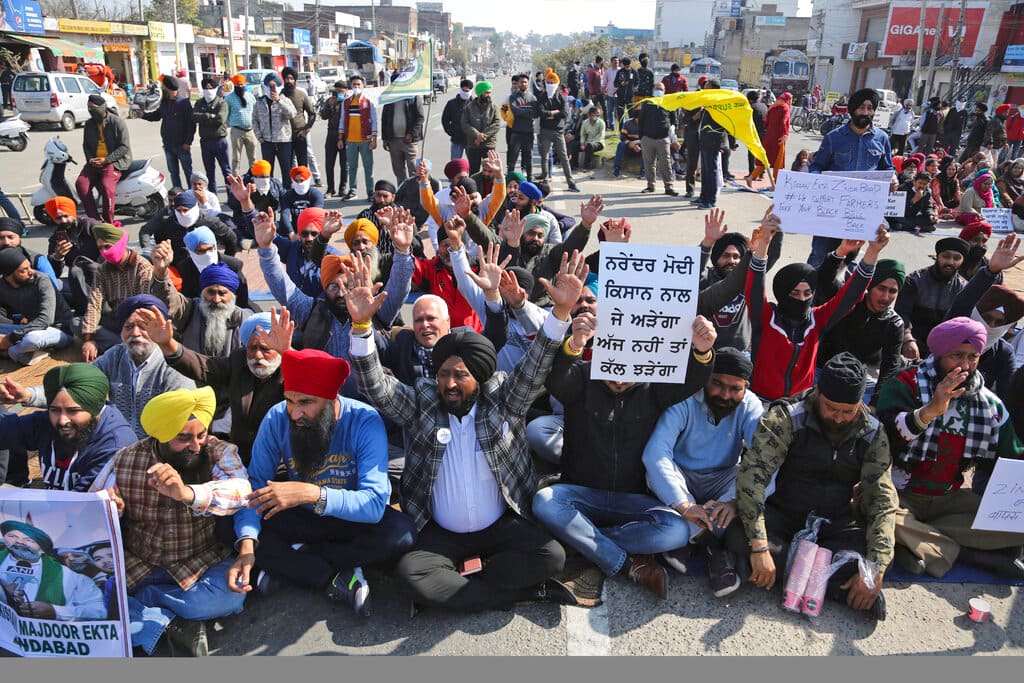 Activists of various parties block the Jammu-Pathankot Highway during a nationwide shutdown called by thousands of farmers protesting new agriculture laws in Jammu on February 6, 2021. (AP Photo/Channi Anand)