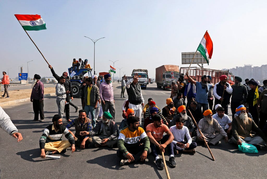 Indian farmers shout slogans as they block an expressway at Kundli in Haryana, India, Saturday, Feb. 6, 2021. Tens of thousands of protesting Indian farmers blocked highways across the country for three hours Saturday to press their demands for the repeal of new agricultural laws. (AP Photo/Manish Swarup)