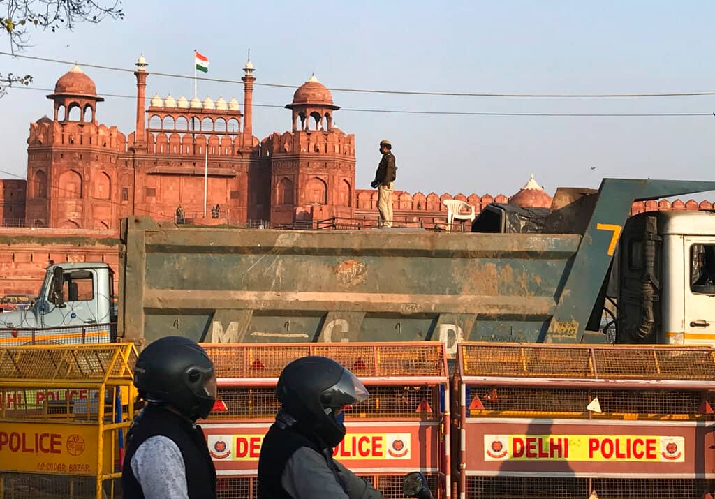 Dumper trucks are placed in front of the historic Red fort as a precautionary measure against protesting farmers entering the area, in New Delhi, India, Saturday, Feb. 6, 2021. Tens of thousands of protesting Indian farmers blocked highways across the country for three hours Saturday to press their demands for the repeal of new agricultural laws. (AP Photo/Rishabh Jain)