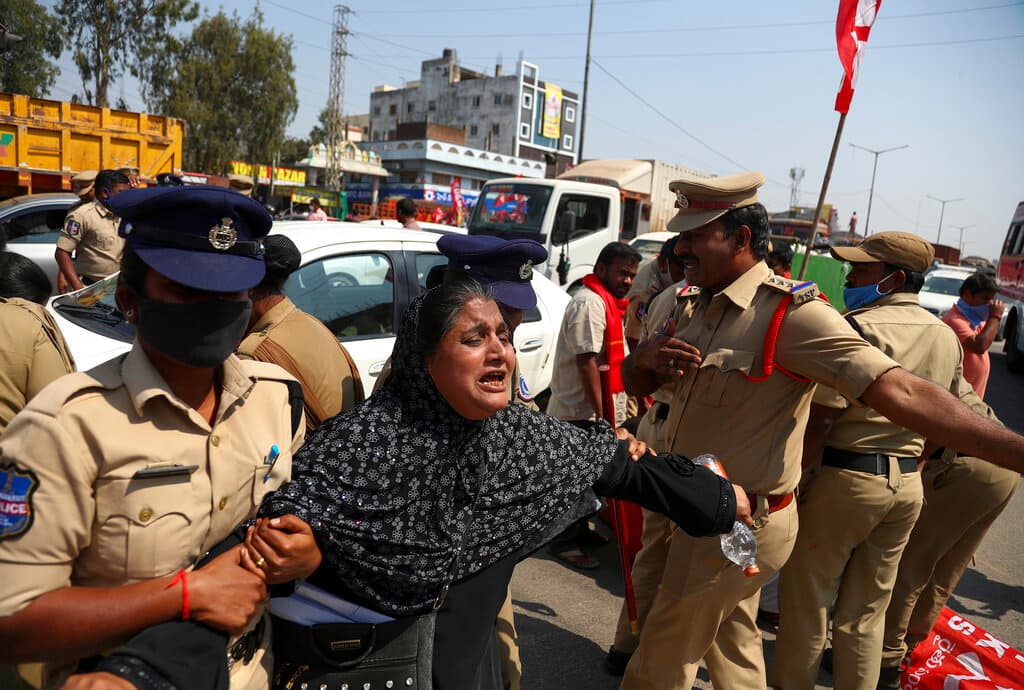 Police detain a protestor blocking a highway during a nationwide shutdown called by thousands of Indian farmers protesting new agriculture laws in Hyderabad, India, Saturday, Feb. 6, 2021. Tens of thousands of protesting Indian farmers plan to blockade highways across the country for three hours Saturday to press their demands for the repeal of new agricultural laws. (AP Photo/Mahesh Kumar A.)