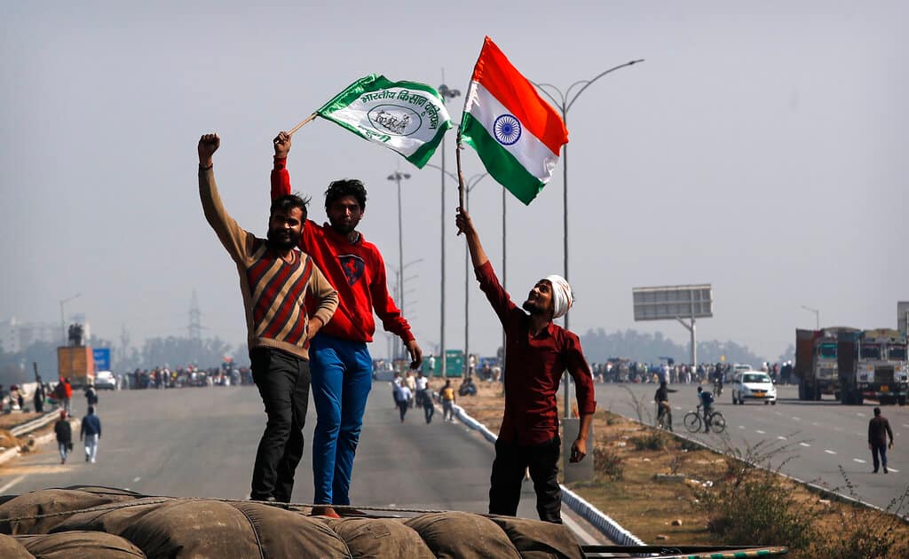 Indian farmers shout slogans standing on the top of a truck as they block an expressway at Kundli in Haryana, India, Saturday, Feb. 6, 2021. Tens of thousands of protesting Indian farmers blocked highways across the country for three hours Saturday to press their demands for the repeal of new agricultural laws. (AP Photo/Manish Swarup)