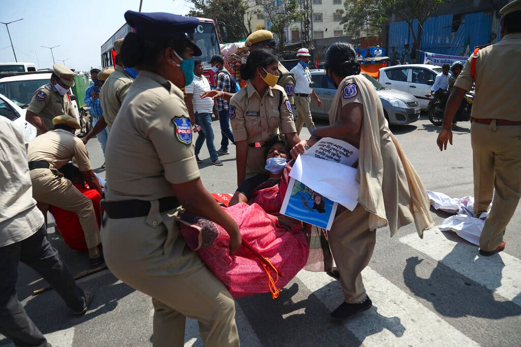 Indian police detain protestors blocking a highway during a nationwide shutdown called by thousands of Indian farmers protesting new agriculture laws in Hyderabad, India, Saturday, Feb. 6, 2021. Tens of thousands of protesting Indian farmers plan to blockade highways across the country for three hours Saturday to press their demands for the repeal of new agricultural laws. (AP Photo/Mahesh Kumar A.)