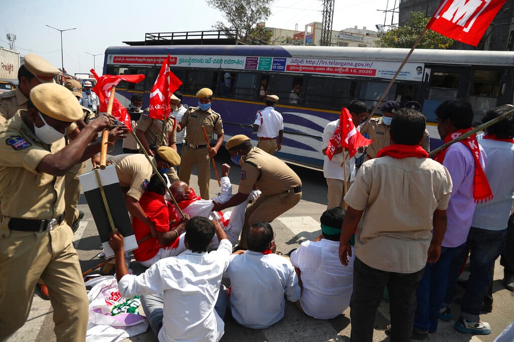 Policemen detain activists of various organisations blocking a highway during the nationwide shutdown called by the Samyukta Kisan Morcha. (AP Photo/Mahesh Kumar A.)