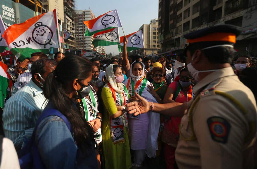 A police officer speaks with members of various political parties as security was beefed up to maintain law and order. (AP Photo/Rafiq Maqbool)