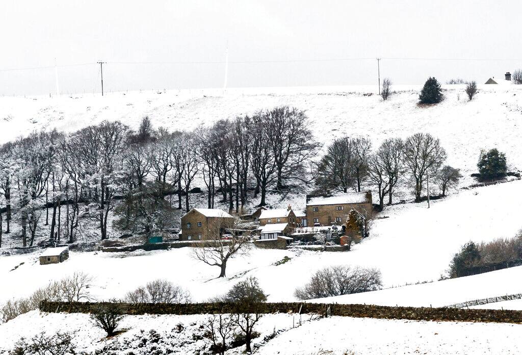 Snow covered buildings near Millhouse Green in north east England, Sunday Feb. 7, 2021, with bitterly cold winds and heavy snow set to bring disruption to some parts of England. (Danny Lawson/PA via AP)