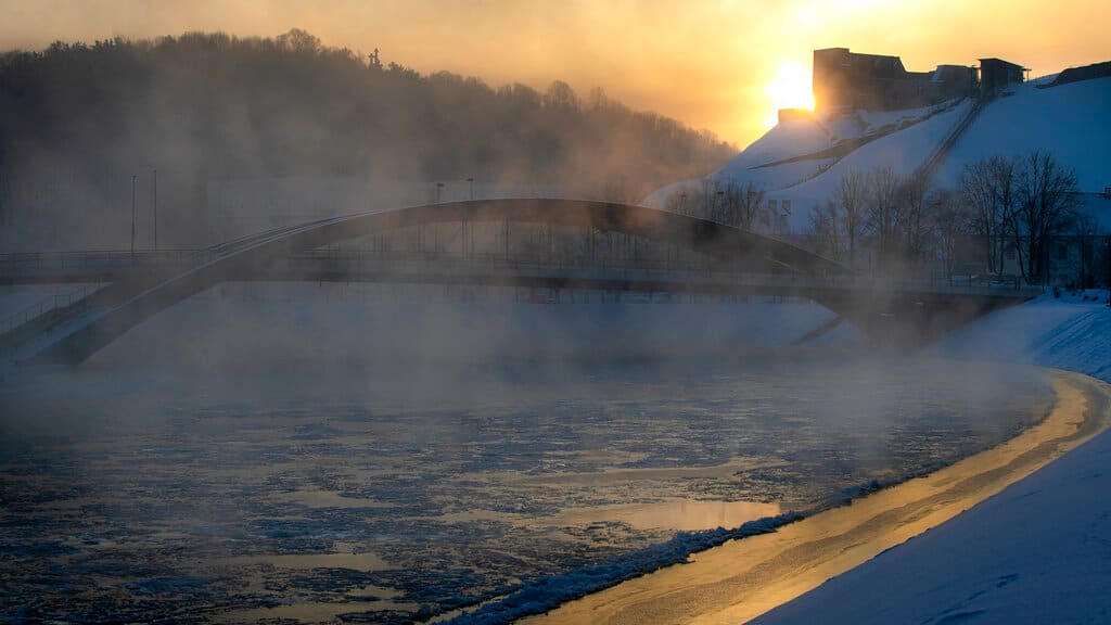 A sun rises over King Mindaugas bridge as temperatures dipped to -21 degrees Celsius (-5.8 degrees Fahrenheit) in Vilnius, Sunday, Feb. 7, 2021. (AP Photo/Mindaugas Kulbis)