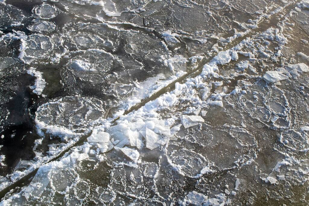 A view of the ice covered Neris River as temperatures dipped to -21 degrees Celsius (-5.8 degrees Fahrenheit) in Vilnius, Sunday, Feb. 7, 2021. (AP Photo/Mindaugas Kulbis)