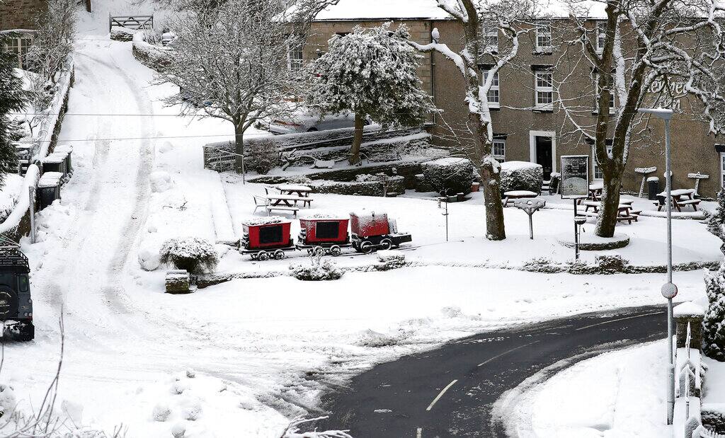 The snow covered scene with one road clear for road traffic at Allenheads, England, Sunday, Feb. 7, 2021. Snow has swept across the region Sunday, with further snowfall predicted to impact on the country bringing travel problems as temperatures drop. (AP Photo/Scott Heppell)