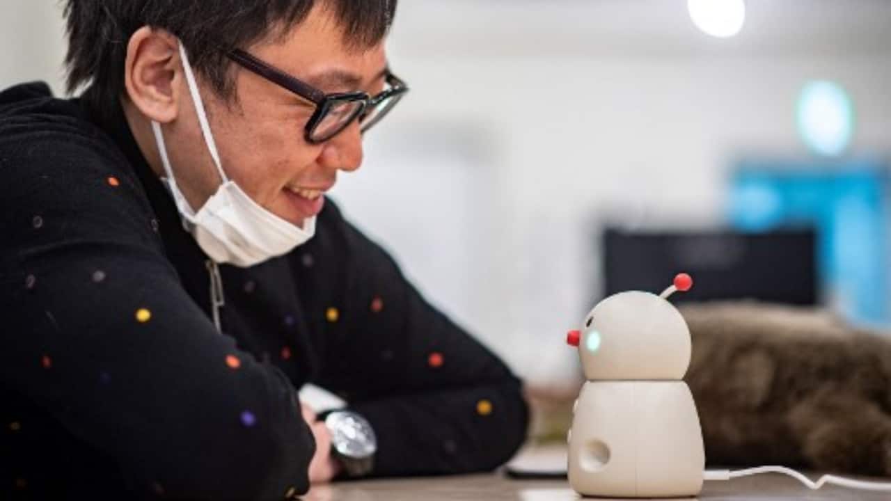 Shunsuke Aoki, CEO of Yukai Engineering, talking with the robot Bocco emo in a studio in Tokyo. (PC-Philip FONG/AFP)