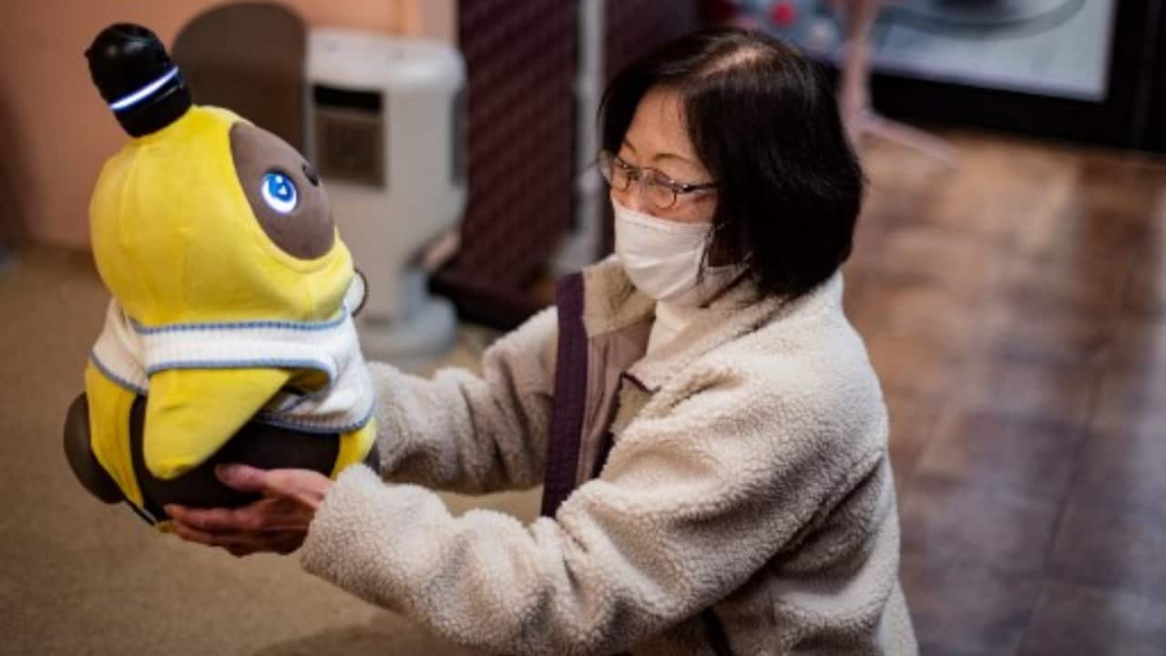 A diner holding a Lovot robot in a cafe in Kawasaki. (PC-Philip FONG/AFP)