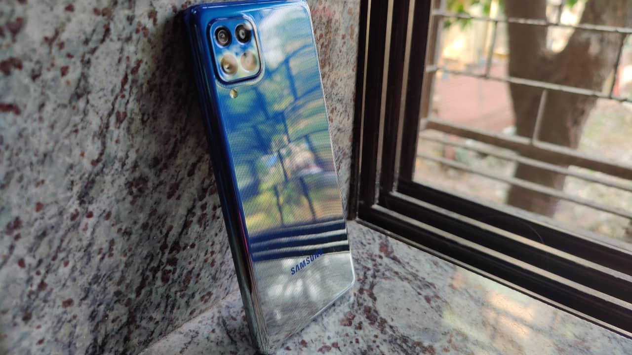 Straight off the bat, the first thing you notice about the F62 is its almost-glass finish, which Samsung calls “Glasstic”. The back may not be glass, but certainly gives the impression of glass. The Galaxy F62 is available in Laser Blue, Laser Green, and Laser Grey colour options, our review unit had the blue finish. The glossy finish looks pretty neat, although it attracts fingerprints way too easily. The camera module on the back blends into the design, while the bump is almost non-existent. 