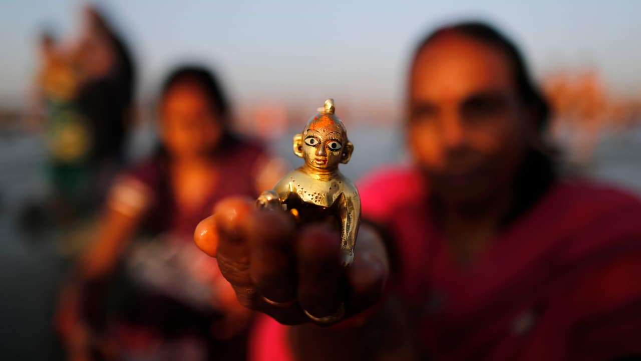 A Hindu devotee offers prayers to the Sun god after taking a holy dip at the Sangam on Maghi Purnima. (PC-AP)