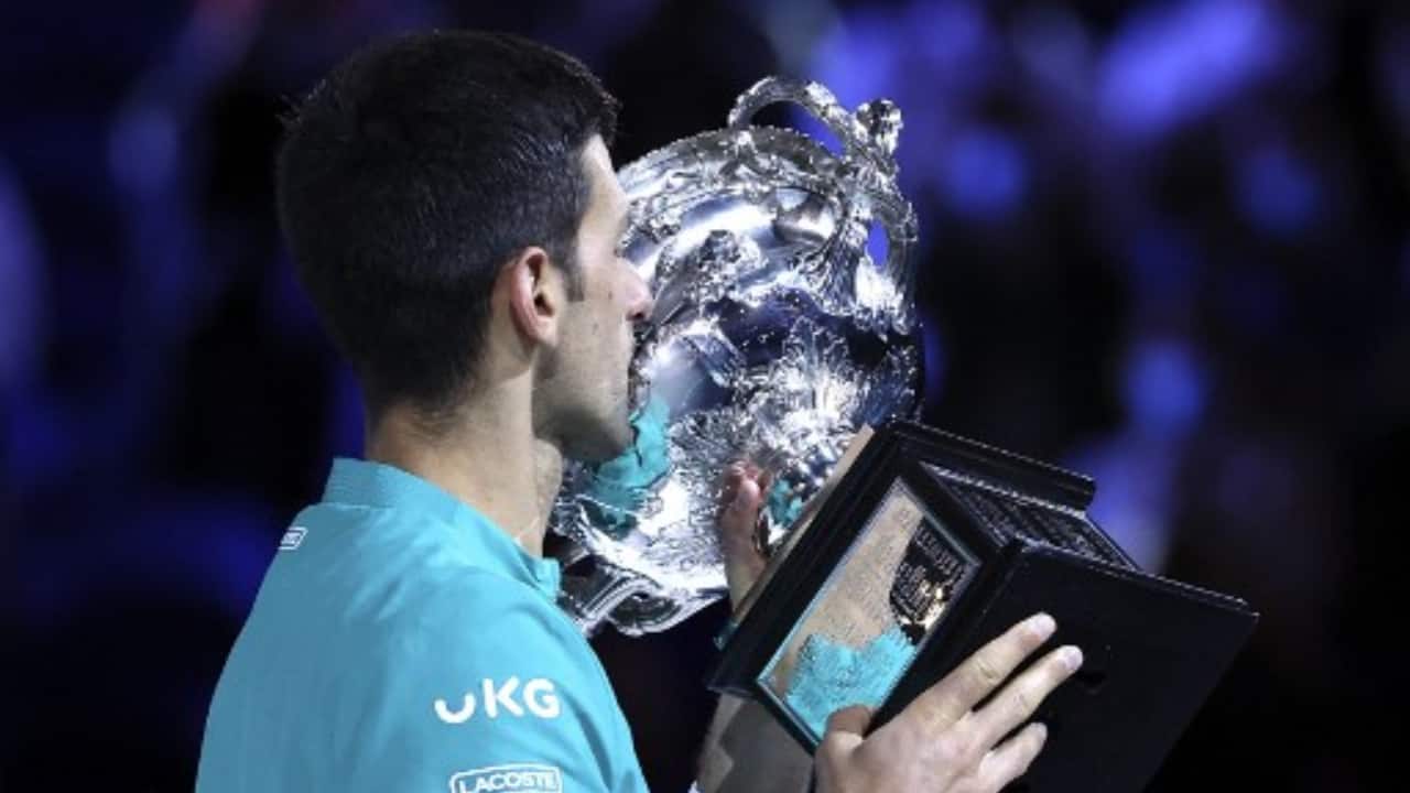 Serbia's Novak Djokovic kisses the Norman Brookes Challenge Cup trophy after beating Russia's Daniil Medvedev to win their men's singles final match on day fourteen of the Australian Open tennis tournament in Melbourne. (PC-Brandon MALONE/AFP)