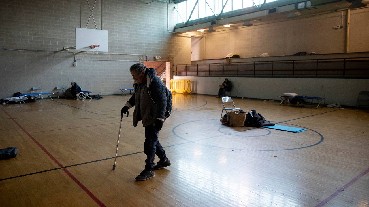Tom Keller walks across the gymnasium floor in a warming shelter at St. Martin's Lutheran Church on West 15th Street in downtown Austin, Texas, February 18, 2021. Church members opened the shelter Sunday and have been sheltering and feeding more than 20 homeless people during the winter storm. (PC-Jay Janner/Austin American-Statesman via AP)