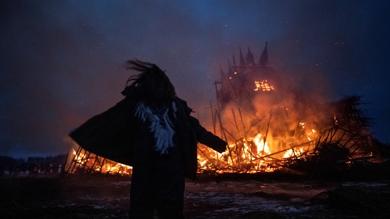 Young woman dances in front of a burning installation called “Vaccination Tower”, during celebrations of Maslenitsa, a pagan holiday, marking the end of the winter in the village of Nikola Lenivets in Kaluga region, Russia March 13. (Image: Reuters)
