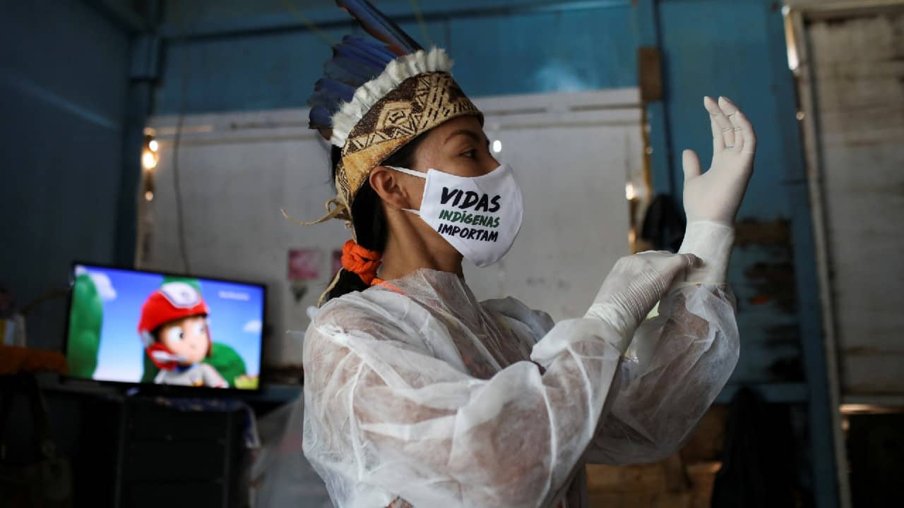 Vanderlecia Ortega dos Santos, 32, a nurse from the Witoto tribe who has volunteered to provide the only frontline care protecting her indigenous community of 700 families from the COVID-19 outbreak, wears a face mask that reads &quot;Indigenous lives matter&quot; as she puts on PPE before leaving her home in Parque das Trios, Taruma district, Manaus, Brazil, April 26, 2020. &quot;Our people are dying from this disease here and they are not being recognized as indigenous people by the state and Sesai,&quot; she said. (Image: Reuters)