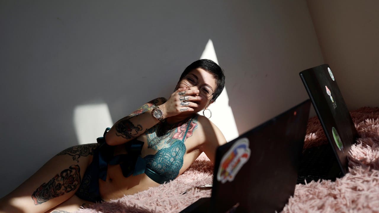 Camila Hormazabal, a 24-year-old sex worker, uses laptops to meet virtually with customers in Concepcion, Chile April 7, 2020. Hormazabal reinvented herself offering sexual services online after the nightclub where she had worked was closed due to the outbreak of the coronavirus. (Image: Reuters)