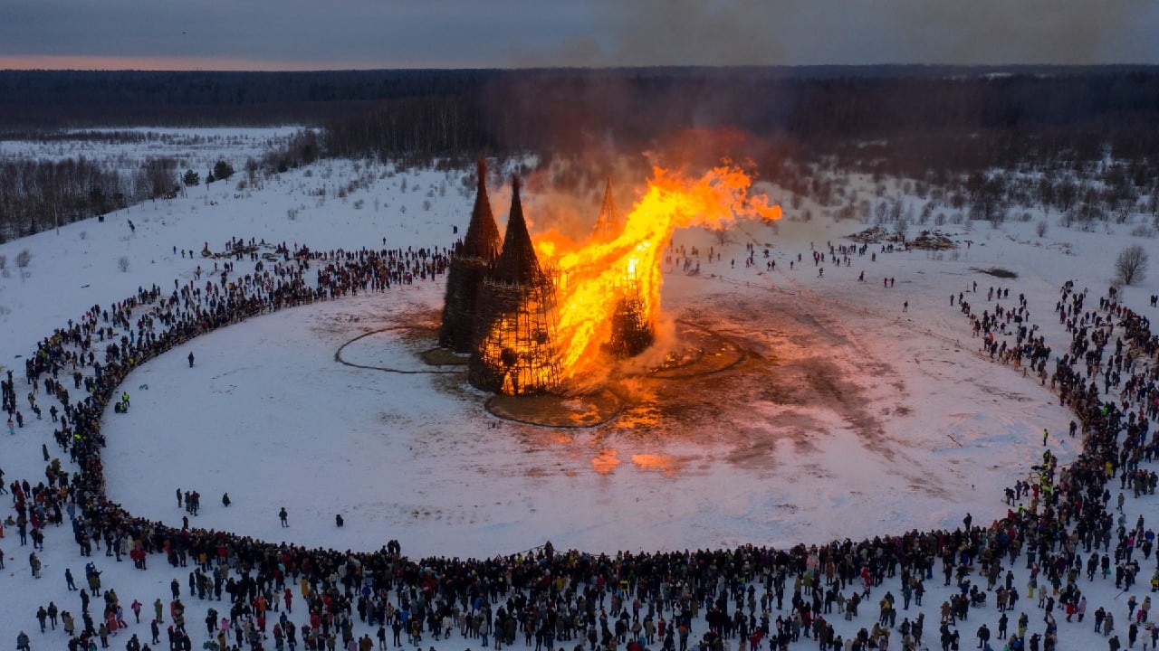 People watch at a burning installation called &quot;Vaccination Tower&quot;, during celebrations of Maslenitsa, a pagan holiday, marking the end of the winter in the village of Nikola Lenivets in Kaluga region, Russia March 13. (Image: Reuters)