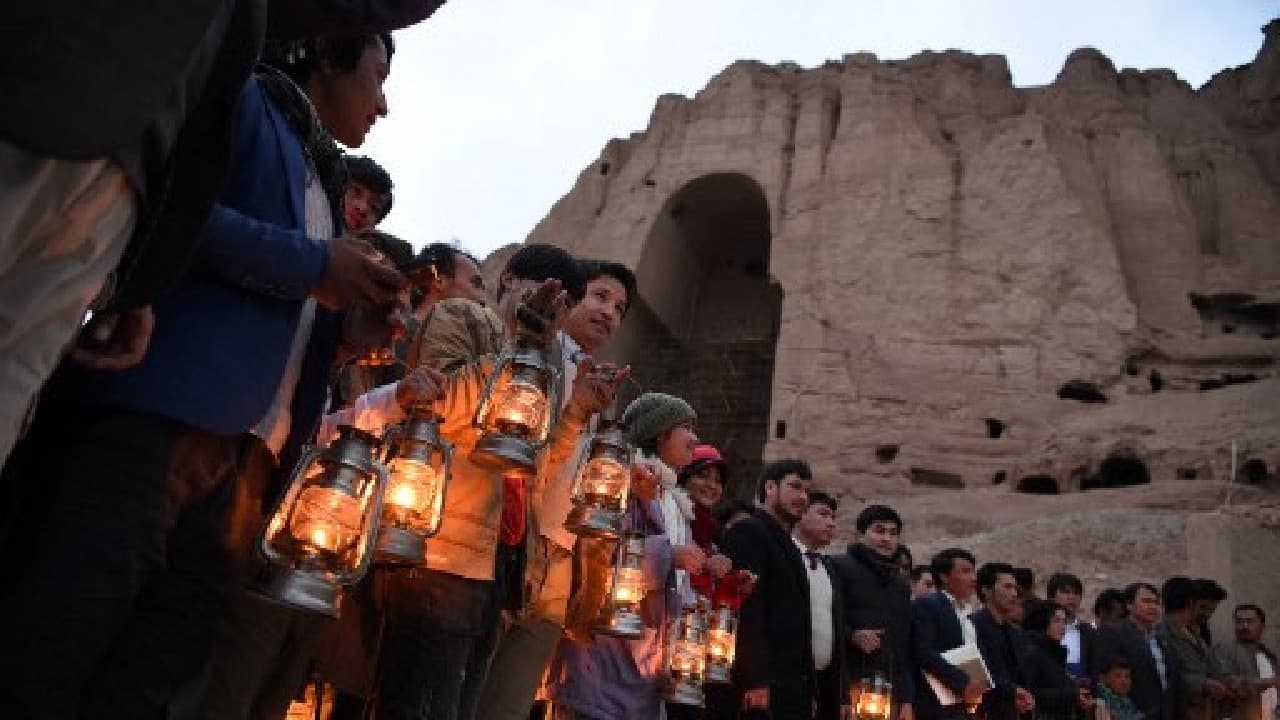 After a lantern-lit procession, hundreds gathered at the base of the cliff where the statues once stood alongside a network of ancient caves, monasteries and shrines. (Image: AFP)