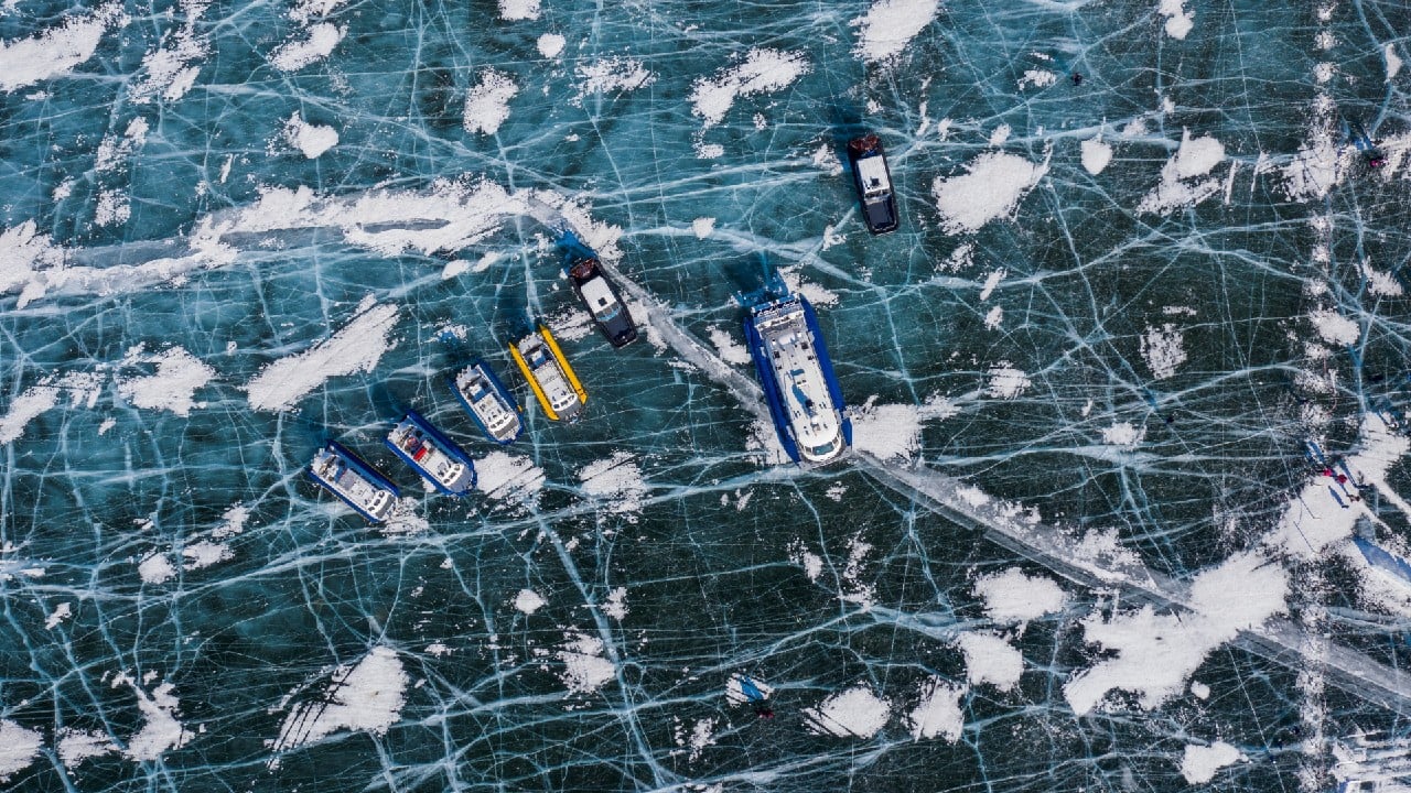 An aerial view shows hoverboats on the ice of lake Baikal near the village of Bolshoye Goloustnoye in Irkutsk region, Russia, March 8, 2021. Lake Baikal remains one of the world's cleanest fresh water reservoirs. But pollution and the growth of weeds are harming microorganisms, sponges and some molluscs that filter its waters. The Baikal pulp and paper mill and its sewage treatment facilities were closed seven years ago, but pollution has spread significantly since then, according to local media. That, some experts say, is because pollution left behind at the industrial site is draining into the lake. (Image: Reuters)