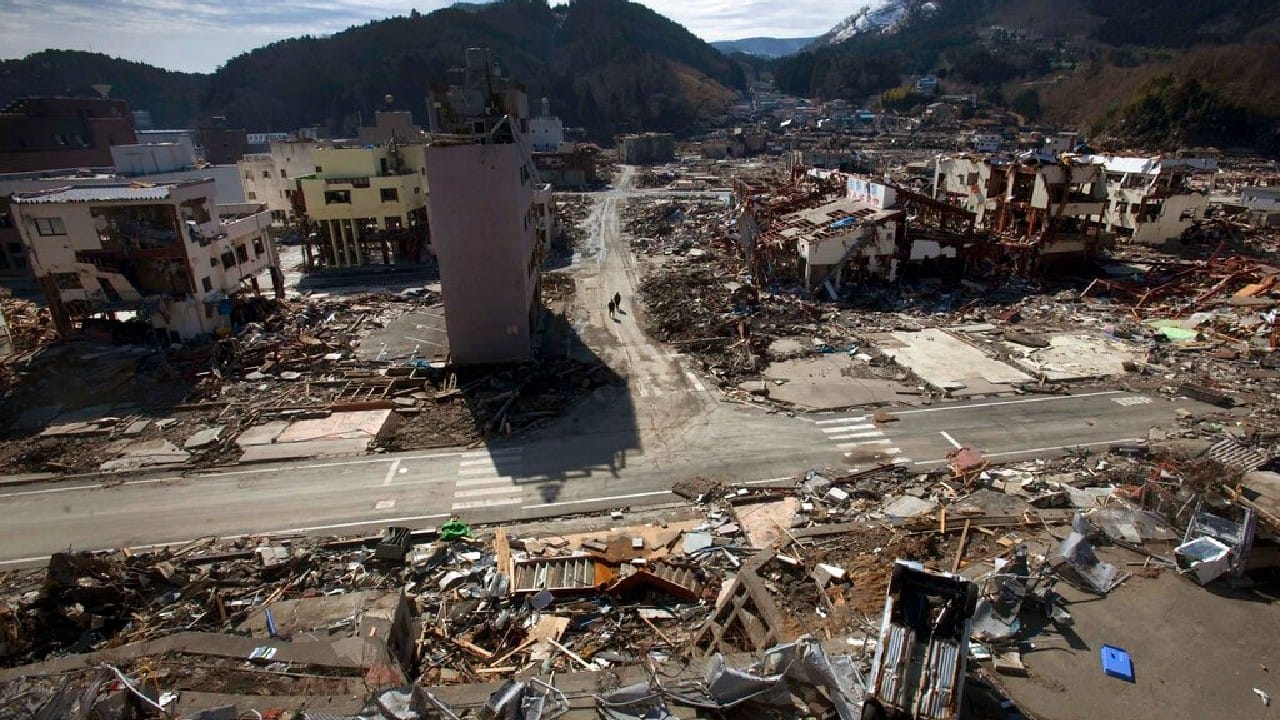 A survivor of the earthquake and tsunami rides his bicycle through the leveled city of Minamisanriku, in northeastern Japan, four days after the Tsunami, March 15, 2011. (Image: AP)