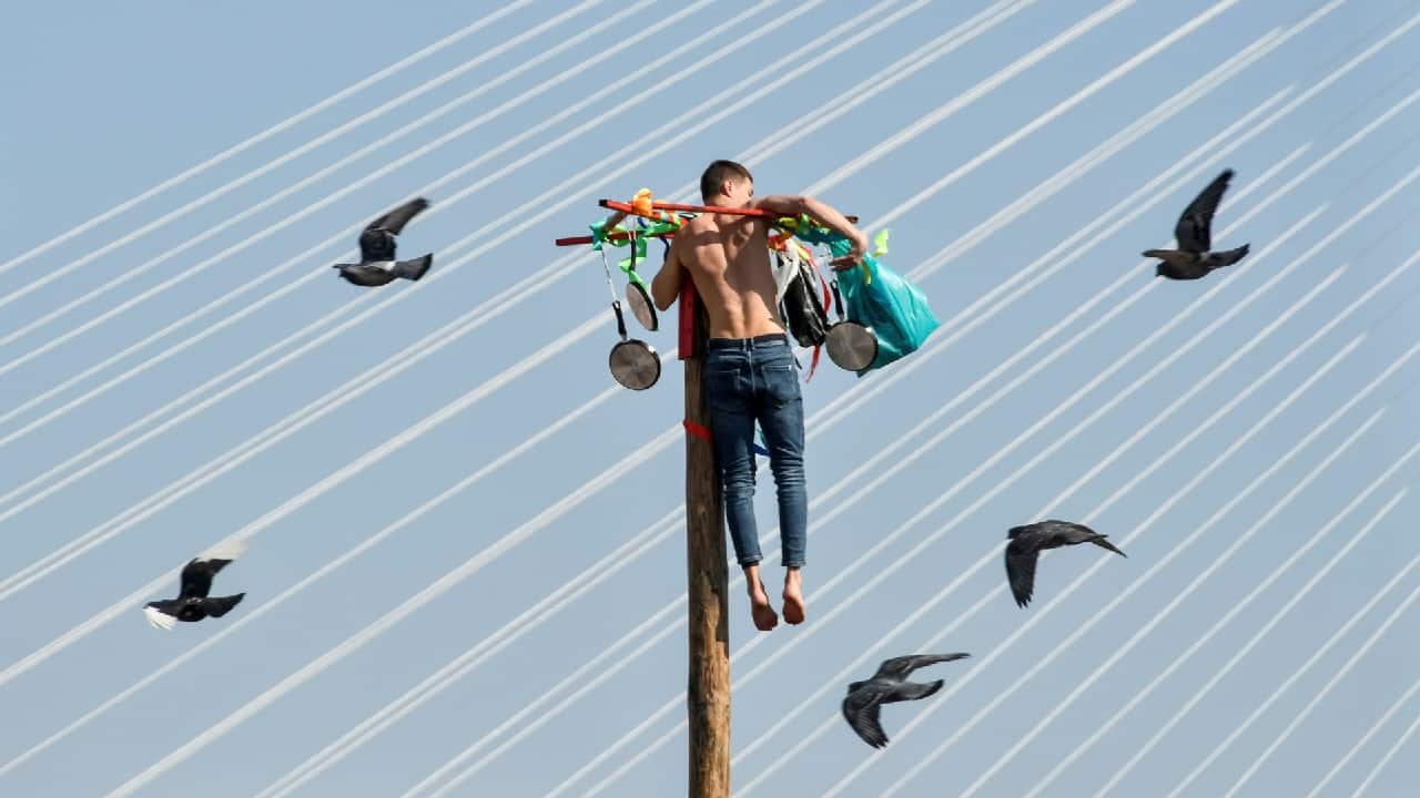 A man climbs up a wooden pole to get a prize during celebrations of Maslenitsa, also known as Pancake Week, which is a pagan holiday marking the end of winter, in Russia's far eastern city of Vladivostok, Russia March 14. (Image: Reuters)