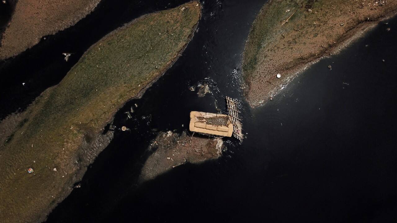 An aerial view shows a discarded sofa on the Tiete river near Ecological Tiete Park in Sao Paulo, Brazil, March 17, 2021. The Rio Tiete, which flows like a vast open sewer though Brazil's largest city Sao Paulo, is among the most polluted in the country. Over 100 km of the river are considered dead or too polluted for almost all marine life. The stinking river, which receives hundreds of tonnes of untreated sewage and waste every day, is a black mark on Brazil's wealthiest city. (Image: Reuters)
