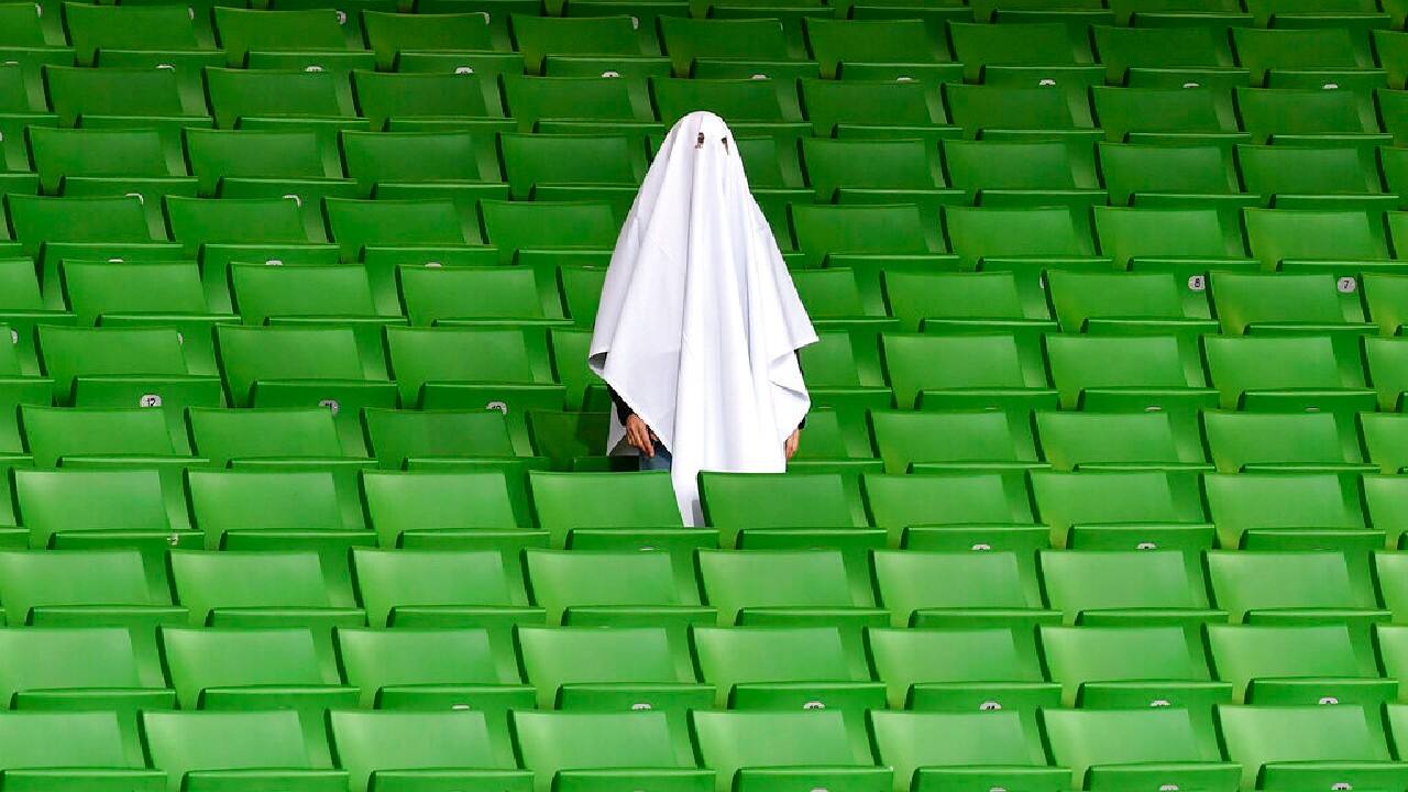 And in Linz, Austria, a lone, ghostlike fan wore a sheet and stood amid the empty seats. (Image: AP)
