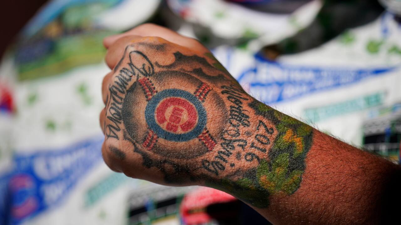 Neal Williamsen, 42, of Chicago, shows his tattoo during a spring baseball game between the Kansas City Royals and the Chicago Cubs in Mesa, Ariz., Tuesday, March 2, 2021. (PC-AP Photo/Jae C. Hong)