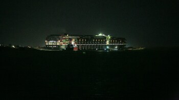 A tugboat beside the Ever Given, a container ship operated by a company called Evergreen, in Suez, Egypt on Saturday, March 27, 2021, which has blocked all traffic in the canal when it became wedged there Tuesday. (PC-Sima Diab/The New York Times)