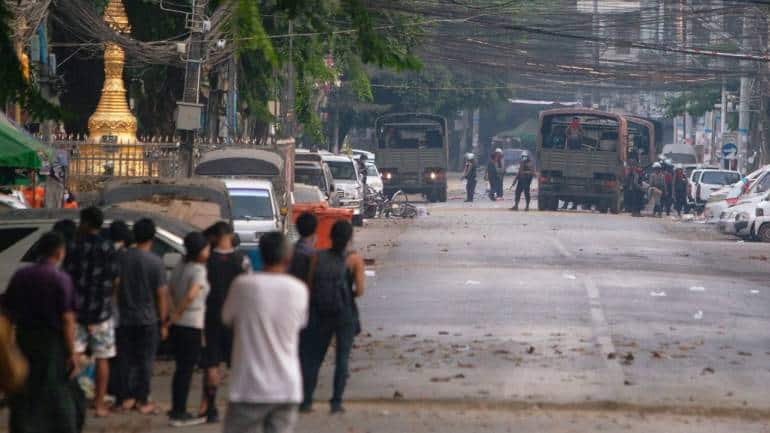 People look at a police vehicle after Sanchaung district has been seized in search of anti-coup demonstrators in Yangon, Myanmar, on March 8. (Image: Reuters/Stringer)