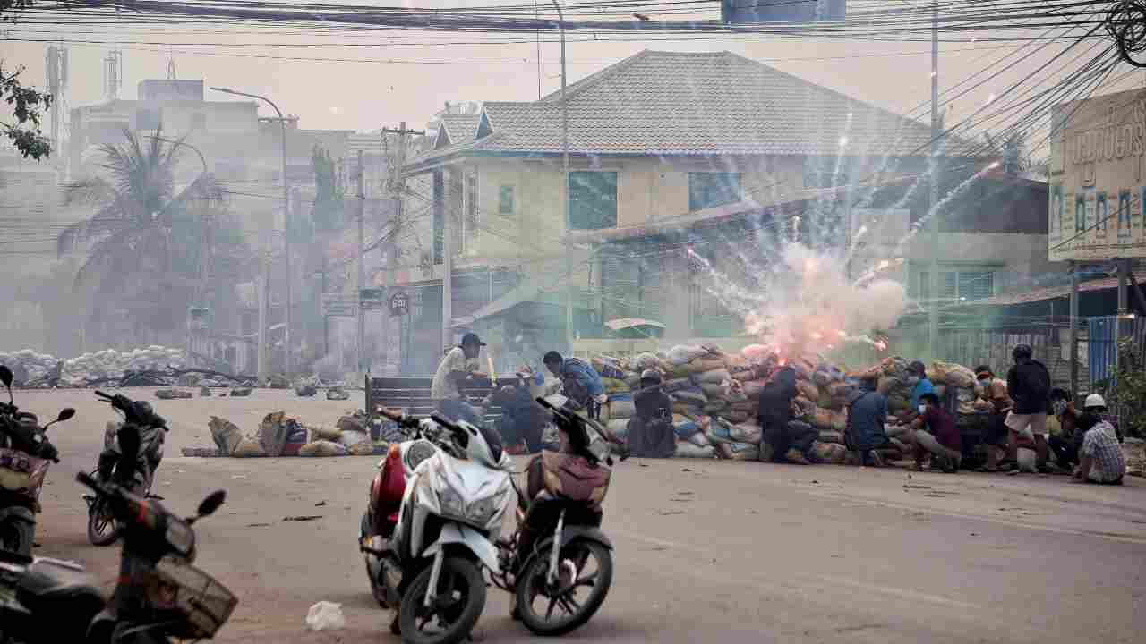 Firecrackers explode as protestors take cover behind a barricade during a demonstration against the military coup in Mandalay, Myanmar. (Image: Reuters)