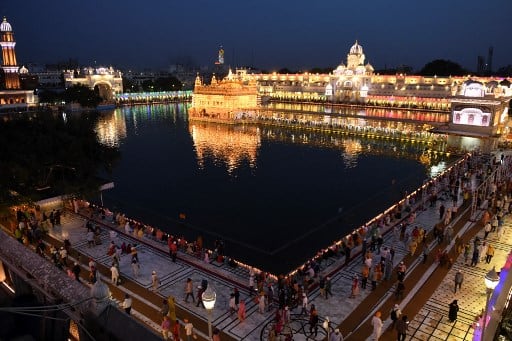 Sikh devotees gather at the Golden Temple on the occasion of the Baisakhi festival, in Amritsar on April 13, 2021. (Photo by NARINDER NANU / AFP)