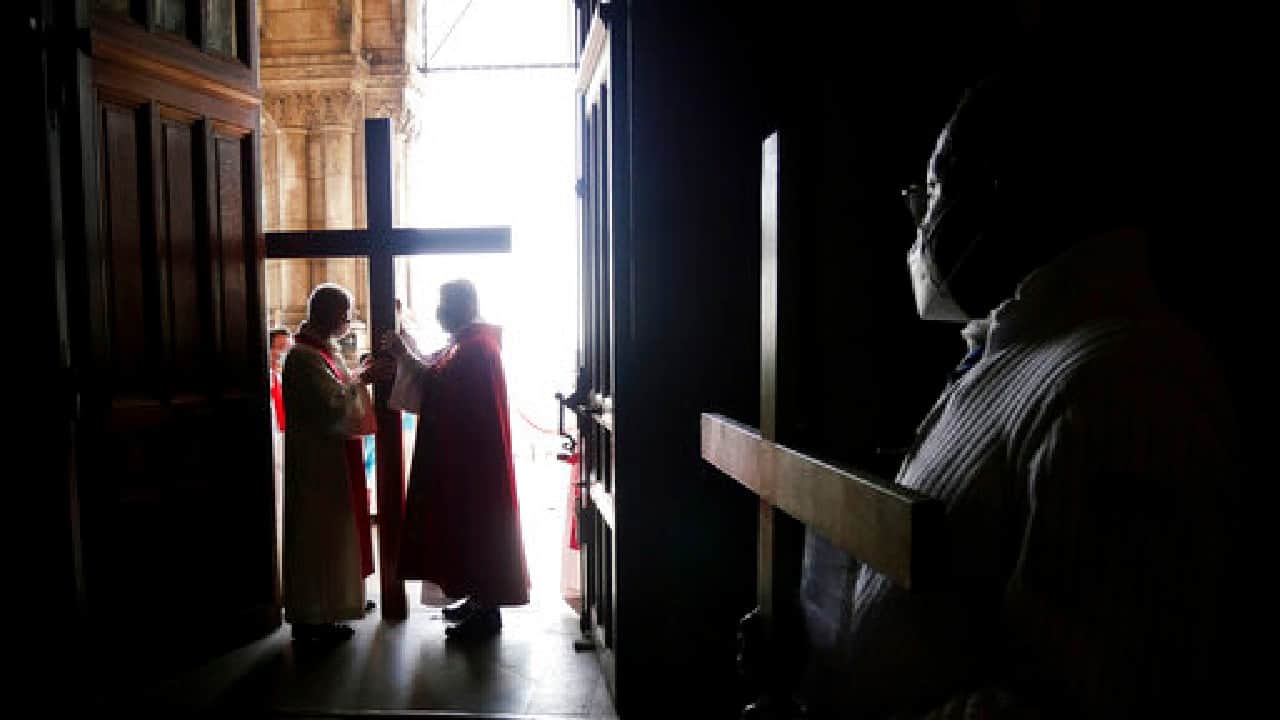 Paris Archbishop Michel Aupetit, center, carries a crucifix during a Way of the Cross ceremony as part of the Holy Easter celebration, in the Sacre Coeur Basilica in Paris, April 2. In France, a nationwide 7 p.m. curfew is forcing parishes to move Good Friday ceremonies forward in the day, as the traditional Catholic night processions are being drastically scaled back or cancelled. (Image: AP)