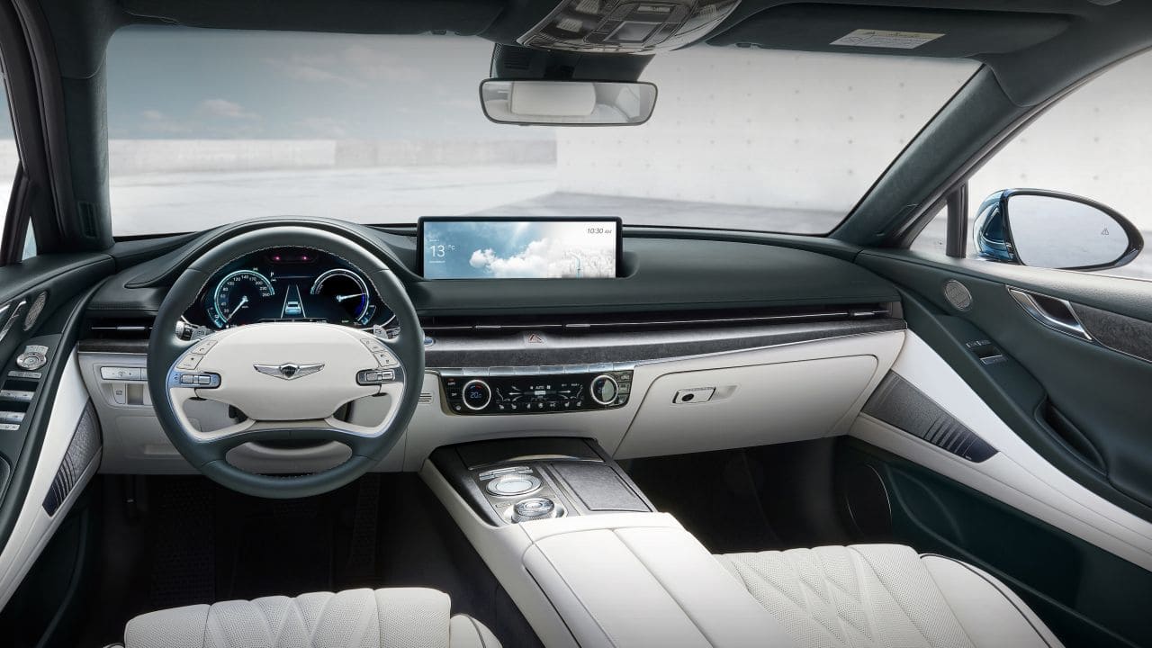 On the inside, the EV is just as luxurious as the standard. It features a dual-tone white and gray theme, leather upholstery and a very wide infotainment unit. (Image source: Genesis) On the inside, the EV is just as luxurious as the standard. It features a dual-tone white and gray theme, leather upholstery and a very wide infotainment unit. (Image source: Genesis)