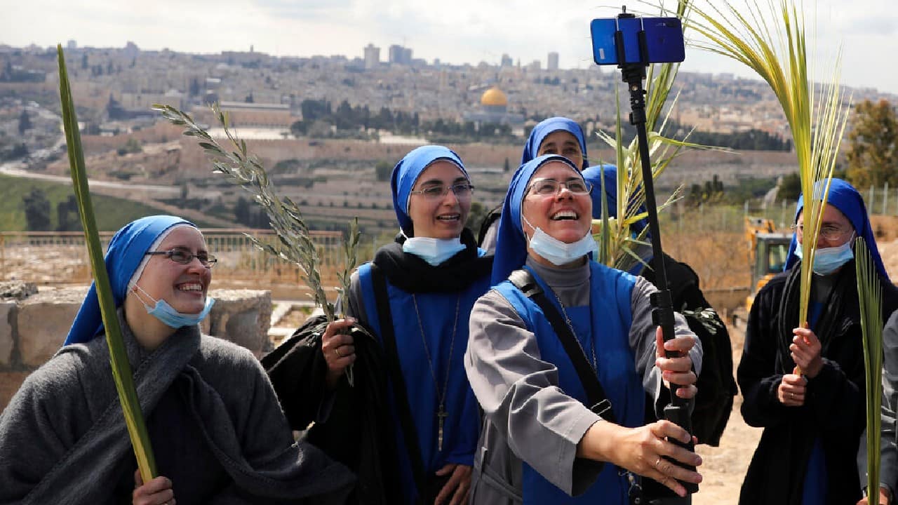 In Israel, beaming nuns took a group selfie atop the Mount of Olives with their masks down below their chins. A year after pandemic restrictions halted mass gatherings, the country has undertaken an aggressive vaccination campaign allowing many aspects of normal life to return. (Image: AP) In Israel, beaming nuns took a group selfie atop the Mount of Olives with their masks down below their chins. A year after pandemic restrictions halted mass gatherings, the country has undertaken an aggressive vaccination campaign allowing many aspects of normal life to return. (Image: AP)