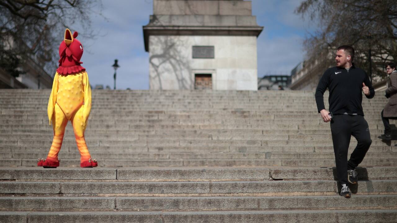 A man jogs past person dressed in a chicken costume on Good Friday in London, Britain. (Image: Reuters)