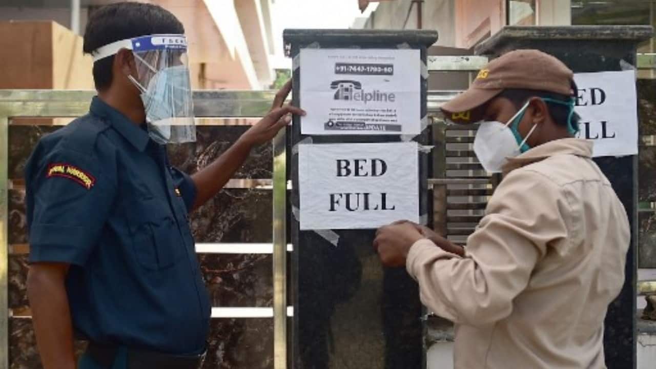 A security guard puts up a notice informing the non-availability of beds for patients in a private hospital amid COVID-19 surge in Allahabad, Uttar Pradesh on April 22, 2021. (Image: Sanjay Kanojia/AFP)