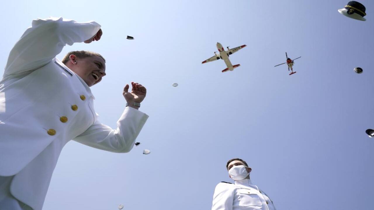 Ensign Charlee Kraiss, left, and Ensign Isaac Lalonde toss their hats in the air as planes fly over at the commencement for the United States Coast Guard Academy in New London, Connecticut, US on Wednesday, May 19, 2021. (Image: AP)