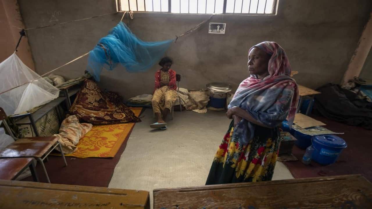 A Tigrayan girl and woman pause in the classroom where they now live at an elementary school used as a camp for the internally-displaced in the town of Abi Adi, in the Tigray region of northern Ethiopia Tuesday, May 11, 2021. Despite claims by both Ethiopia and Eritrea that they were leaving, Eritrean soldiers are in fact more firmly entrenched than ever in Tigray, The Associated Press has found. (AP Photo/Ben Curtis)