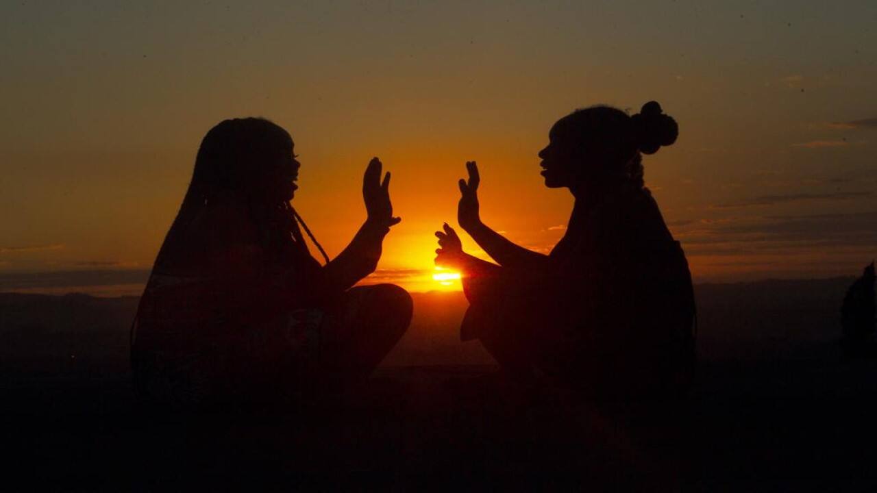 Two girls have fun while playing on top of a hill at sunset on Africa Day in Harare, Tuesday, May, 25, 2021. Zimbabwe marked Africa Day along with the rest of the continent, by celebrating the progress that Africa has made while reflecting upon the common challenges that the continent faces in a global environment.(AP Photo/Tsvangirayi Mukwazhi)