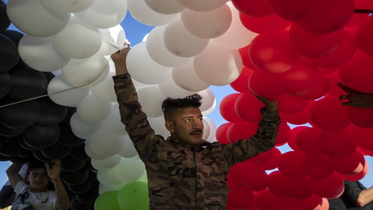 A supporter of Syrian President Bashar Assad prepares to release hundreds of balloons with the colors of the Syrian flag at a gathering at Omayyid Square in the Syrian capital Damascus, Syria, Sunday, May 23, 2021. The presidential elections in the war-ravaged country was held on May 26. (Image: AP)