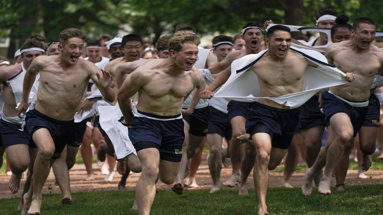 Midshipmen 4th Class from the 14th Company rip their shirts as they run toward the Herndon Monument during the Herndon Monument Climb at the U.S. Naval Academy, Saturday, May 22, 2021, in Annapolis, Md. Freshmen, known as Plebes, participate in the climb to celebrate finishing their first year at the academy. The climb, which took 3:41 hours to complete, was reached when Midshipman 4th Class Michael Lancaster, 19, center, of Signal Hill, Tenn., of the 14th Company, placed a cover atop the monument. (AP Photo/Julio Cortez)