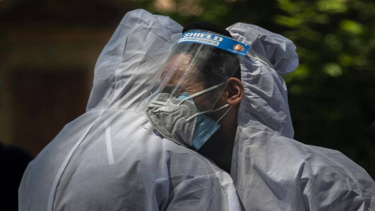 A relative comforts the wailing son of a person who died of COVID-19, at a crematorium in Srinagar, Indian controlled Kashmir, Friday, May 28, 2021. India's death toll is the third-highest reported in the world after the U.S. and Brazil. (AP Photo/Dar Yasin)