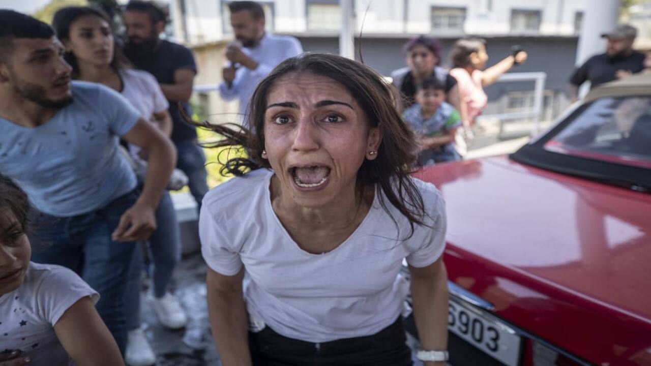 A Syrian woman screams for help for her husband who was injured by stone throwing by members of the Lebanese Forces group, who attacked buses carrying Syrians traveling to vote in the town of Zouk Mosbeh, north of Beirut, Lebanon, Thursday, May 20, 2021. Mobs of angry Lebanese men attacked vehicles carrying Syrians expatriates and those who fled the war heading to the Syrian embassy in Beirut on Thursday, protesting against what they said was an organized vote for President Bashar Assad. (Image: AP)